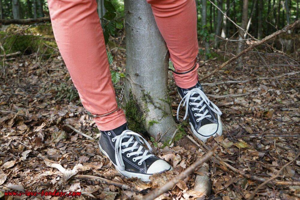 Clothed girl in canvas sneakers finds herself handcuffed to a tree in woods - #13