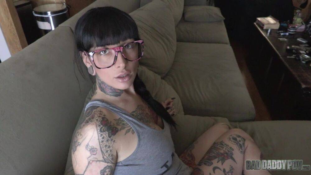 Tattooed brunette exposes her enhanced tits while on a bed - #1
