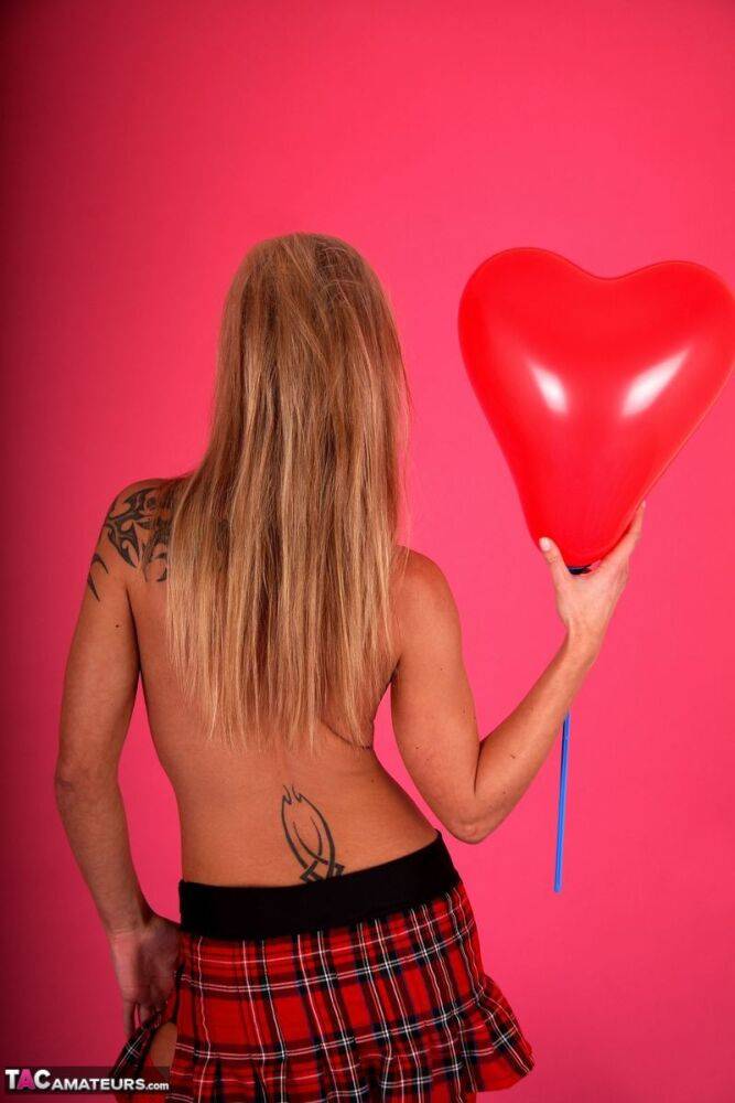 Blonde amateur Susy Rocks models topless in a plaid miniskirt amid balloons - #8