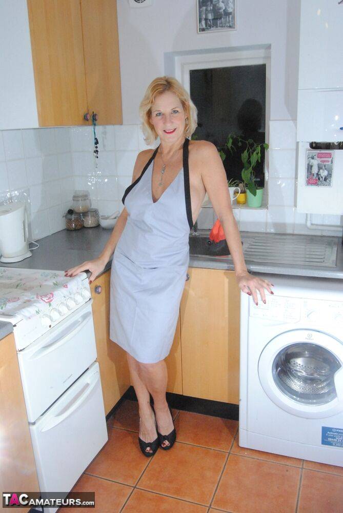 Mature MILF with blonde hair wears only an apron while devouring a banana - #6