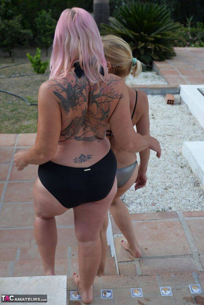 Mature amateurs share a lesbian kiss in their swimwear on poolside patio - #9