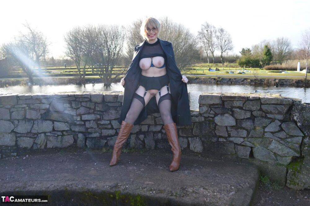 Mature blonde Barby Slut exposes her tits and twat in leather coat by a river - #12