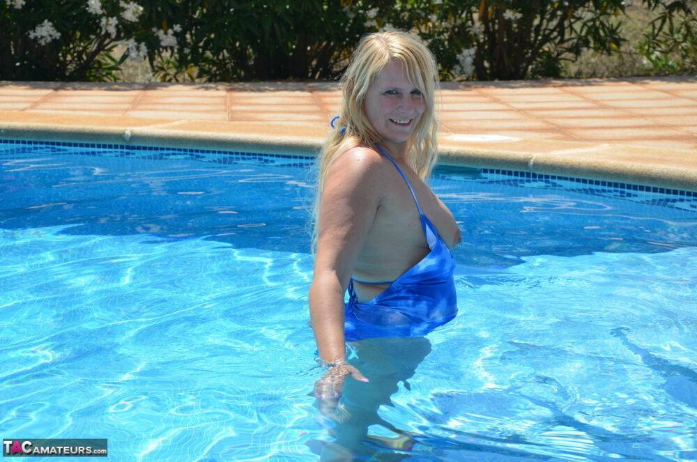 Older blonde Sweet Susi frees her tits and ass from a bathing suit in a pool - #3
