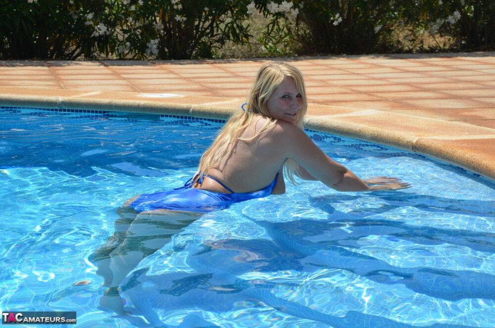 Older blonde Sweet Susi frees her tits and ass from a bathing suit in a pool - #5