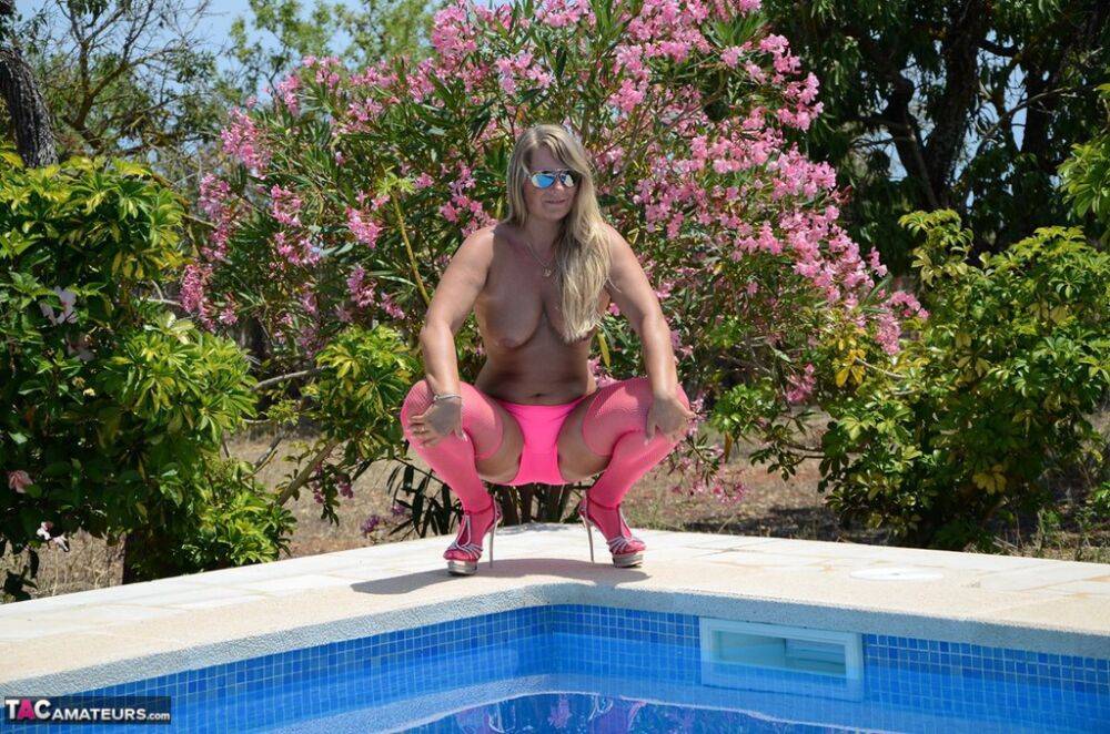 Over 30 blonde Sweet Susi gets naked beside a pool in pink hosiery and shades - #16
