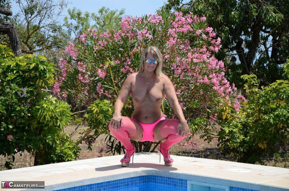 Over 30 blonde Sweet Susi gets naked beside a pool in pink hosiery and shades - #4