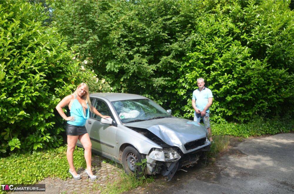 Older blonde Sweet Susi sucks a dick by a wrecked automobile in the backyard | Photo: 1330245