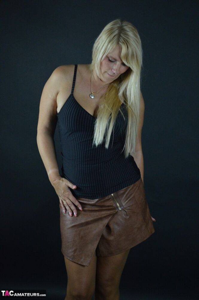 Thick blond amateur Sweet Susi takes off a leather skirt while wearing hose | Photo: 1330327