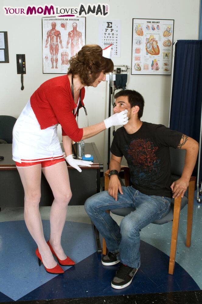 Mature nurse Elle Denay swaps oral with a young boy after cleaning his wounds - #1