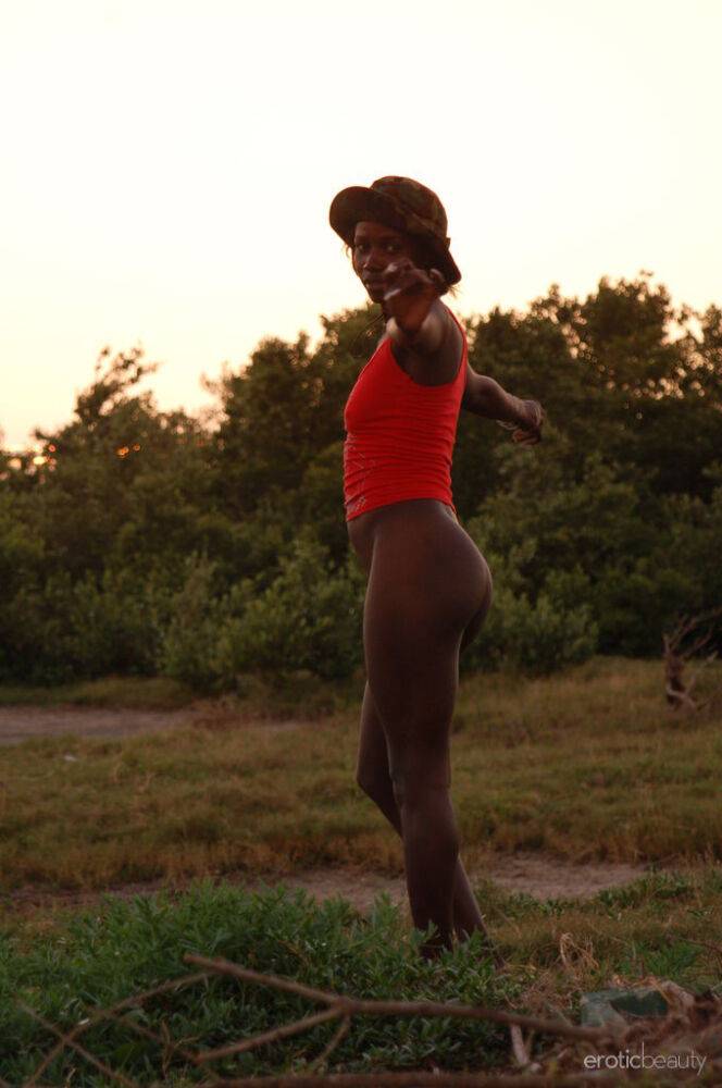 Black girl Maria L displays her naked body in a field near the sea - #8