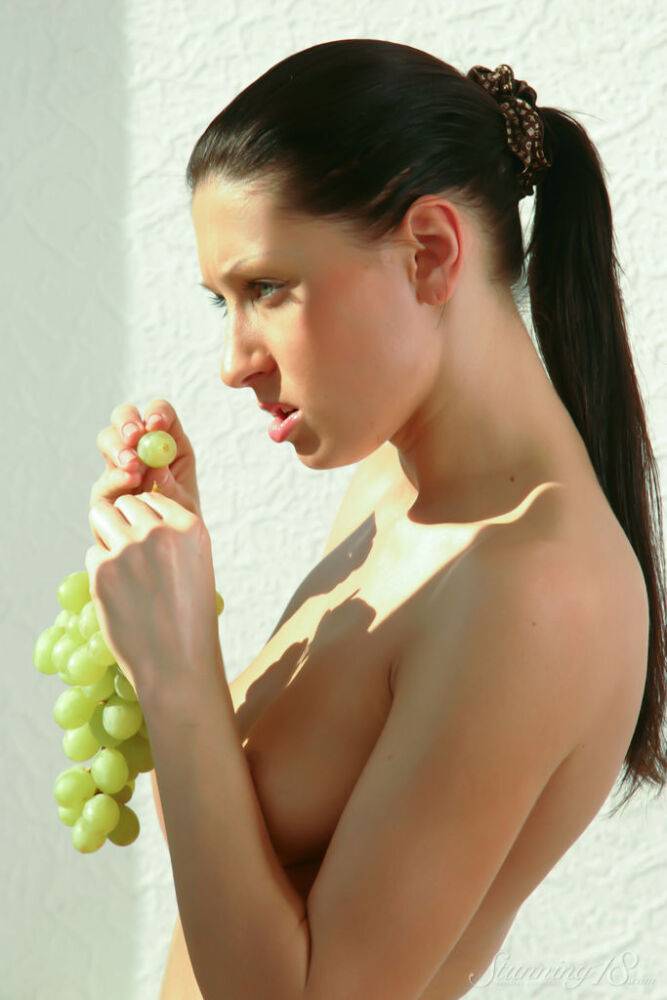 Barely legal girl Bellanca L holds a bunch of grapes while modelling naked - #3