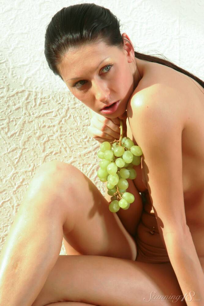 Barely legal girl Bellanca L holds a bunch of grapes while modelling naked - #4