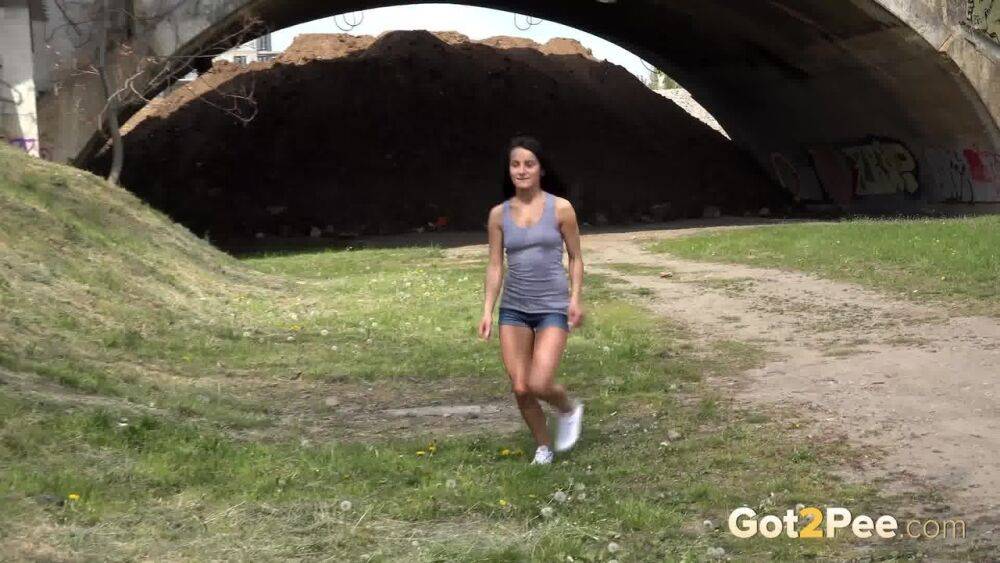 Dark haired traveler Lexi looks for a place to pee and pisses under a bridge - #9