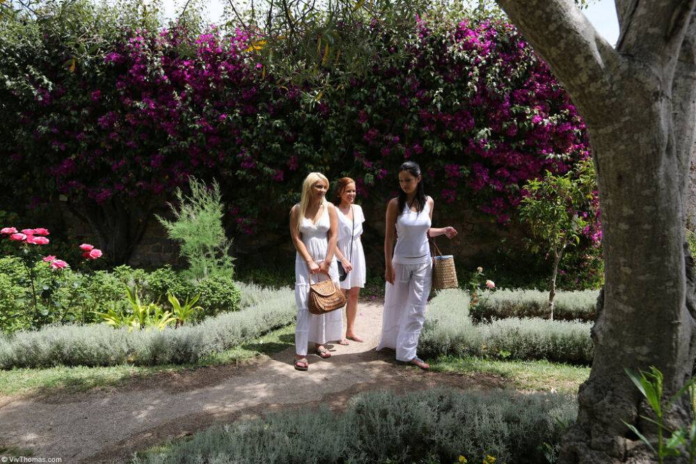 Clothed lesbians splash in a fountain before stopping to smell the flowers - #1