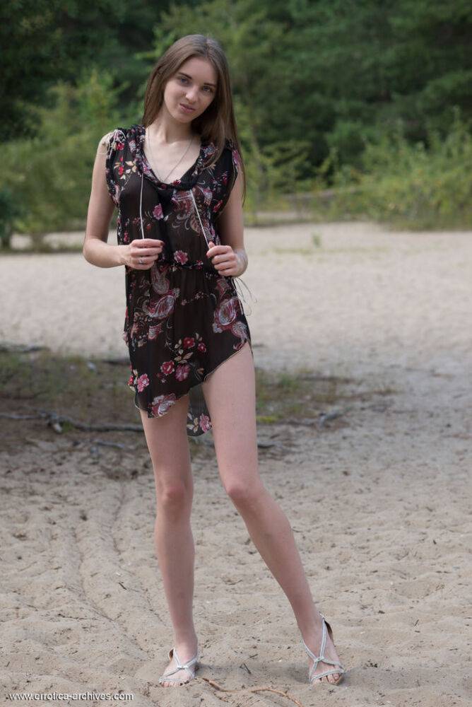 Skinny teen Vialika takes off her dress to stand totally naked on a sand patch - #8