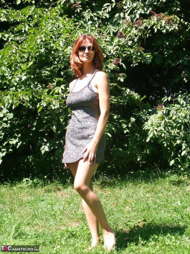 Hot redhead amateur Vanessa disrobes under a tree to air her big saggy tits - #1