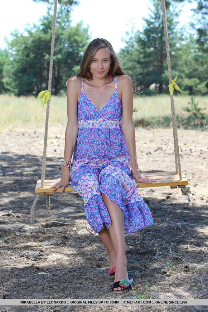 Long legged teen Mirabella doffs a dress to pose nude on a swing under a tree - #14