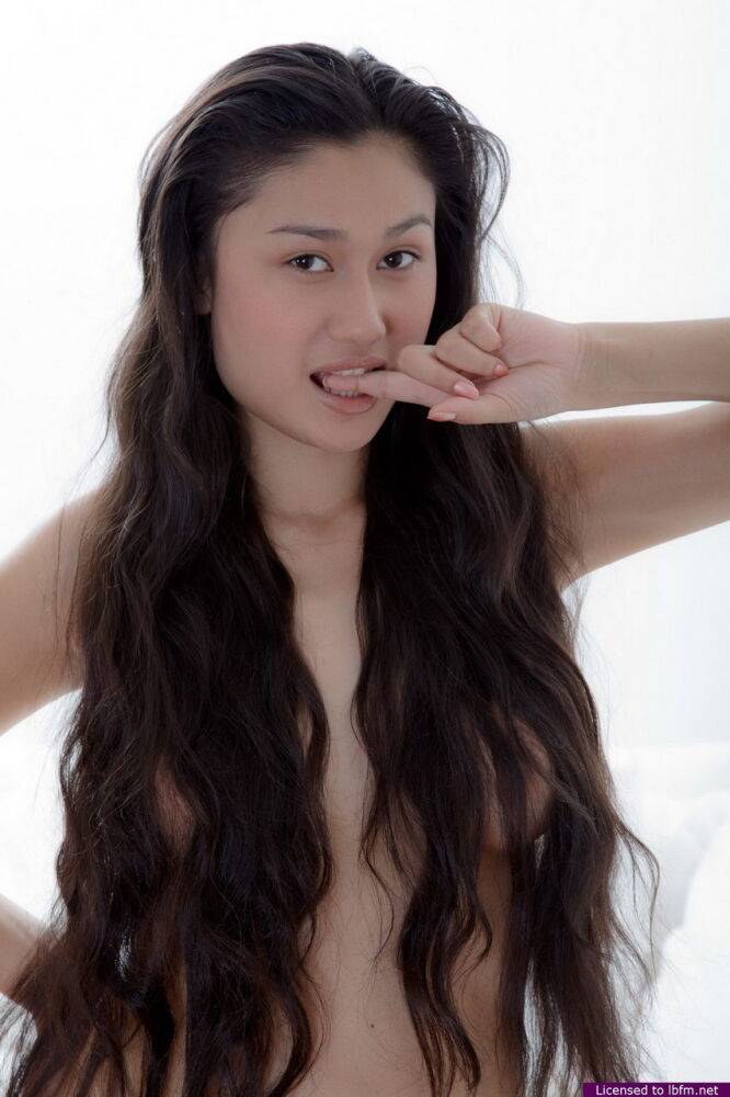 Young Asian girl with long hair holds her naked body during a solo shoot - #11