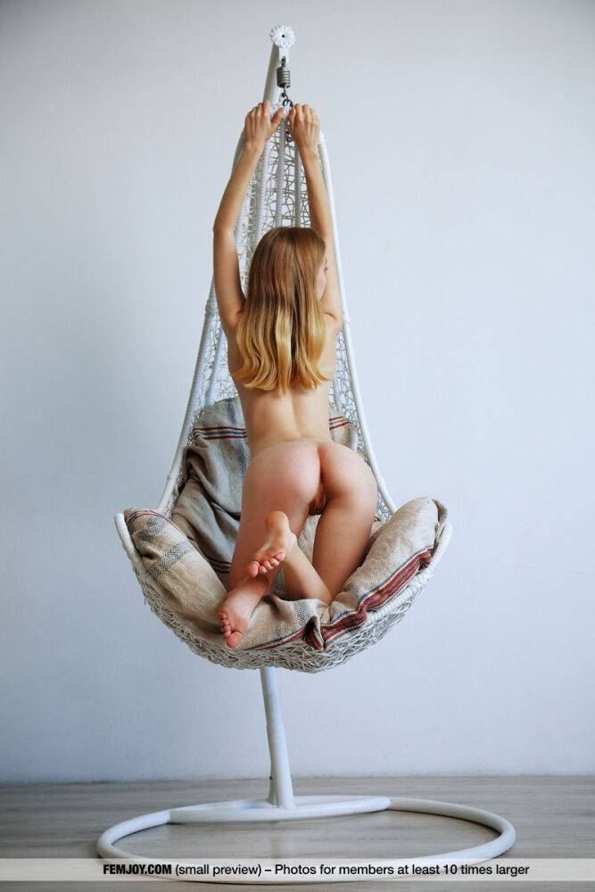 Young looking girl displays her bald pussy in a hanging basket chair - #16