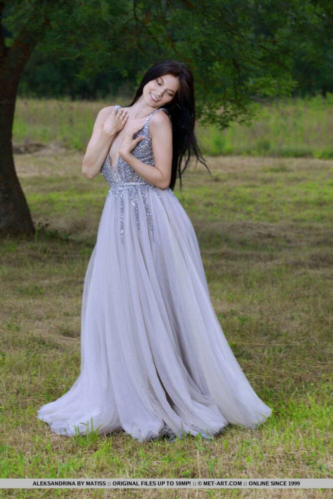 Dark haired teen Aleksandrina slips off a prom dress to pose naked in a field - #14