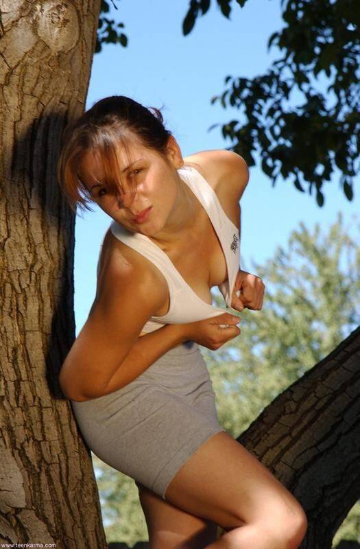Petite teen Karma strips off her clothes to pose nude up in a tree - #2