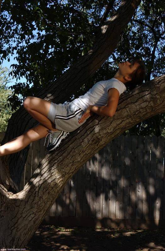 Petite teen Karma strips off her clothes to pose nude up in a tree - #5