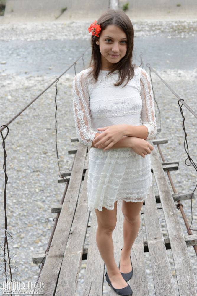 Petite teen wears a flower in her hair while posing nude on suspension bridge - #12