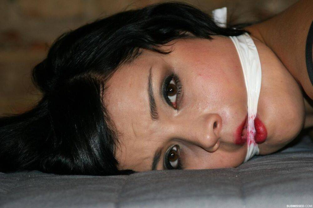 Gagged brunette female is left hog-tied and face down on a mattress - #1