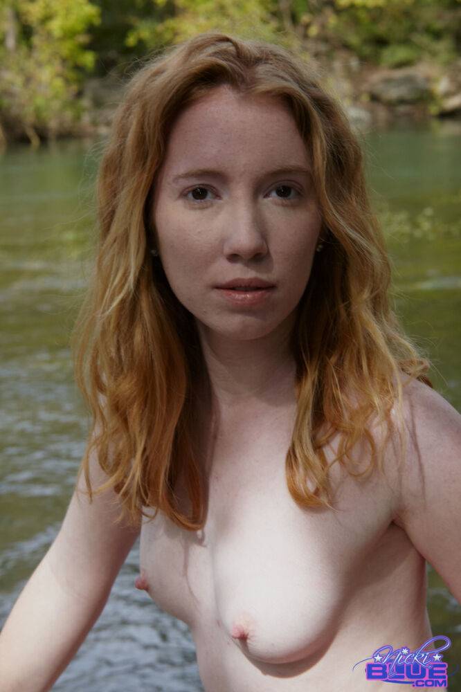 Young redhead Nicki Blue bare her small tits while standing in a stream - #5