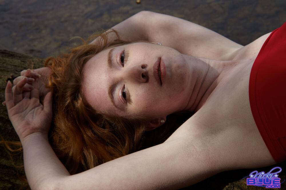 Young redhead Nicki Blue bare her small tits while standing in a stream - #6