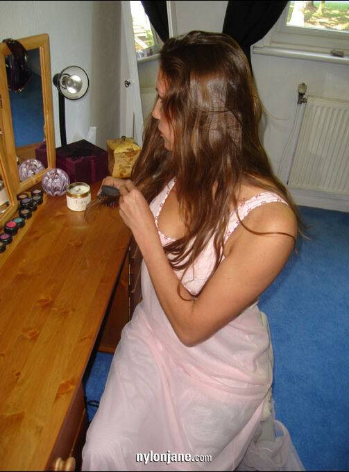 Older woman brushes her long hair in a mirror wearing nylons and garter belt - #12