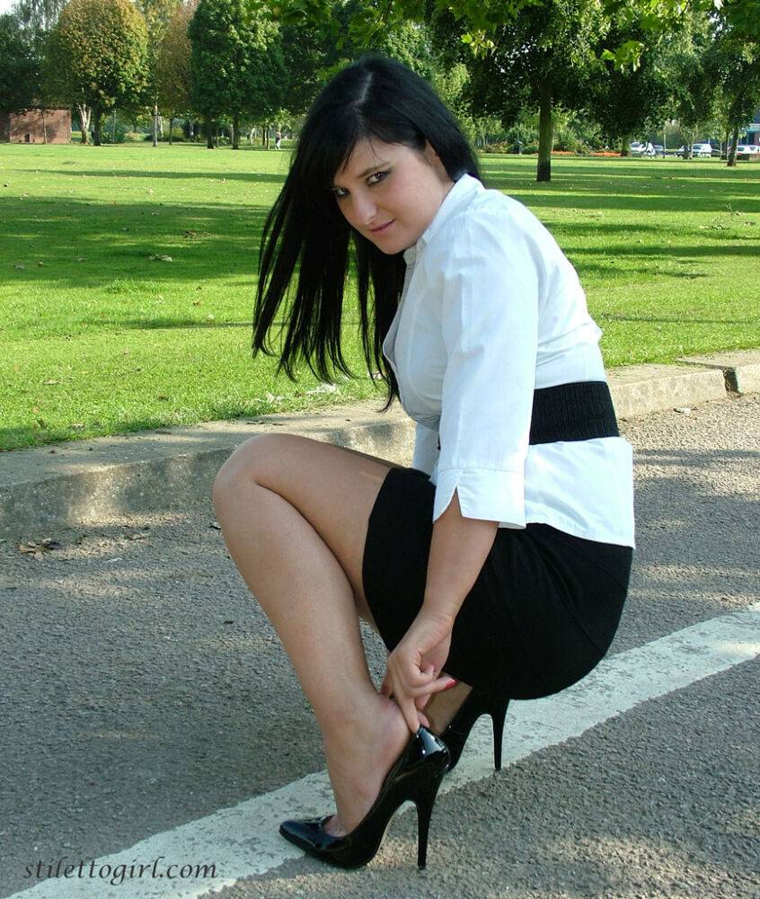 Dark haired female displays some leg and her stiletto heels on a park bench - #7