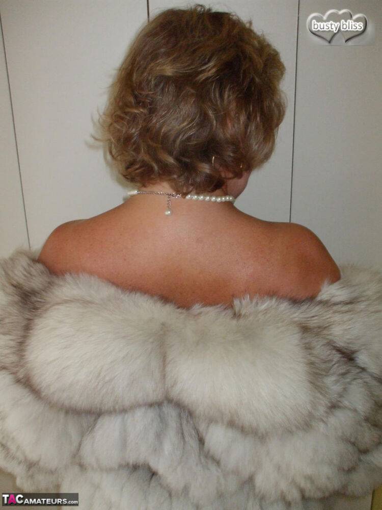 Mature amateur Busty Bliss exposes her tan lined tits while wearing a fur coat - #1