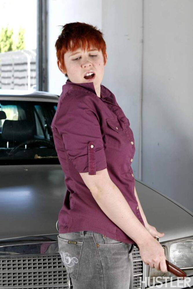 Short haired redhead Lily Cade strips naked atop a car in a garage - #16