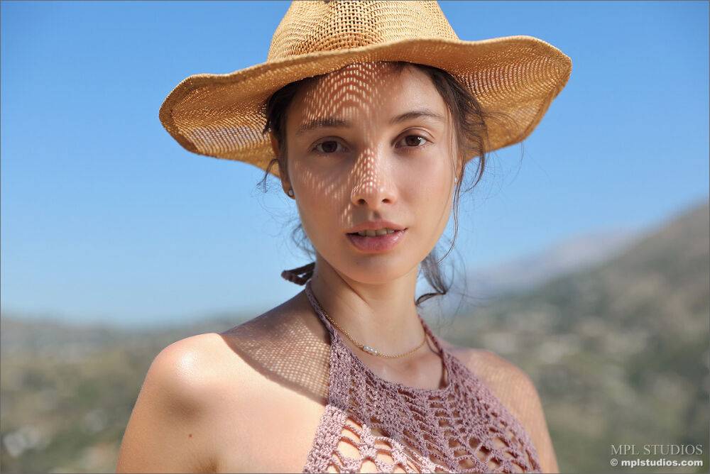 Solo model takes off a sun hat to pose totally naked on a patch of rubble - #7