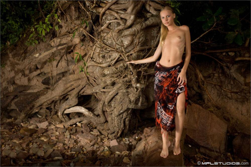 Skinny blonde removes a wrap to pose nude inside a sea cave - #6