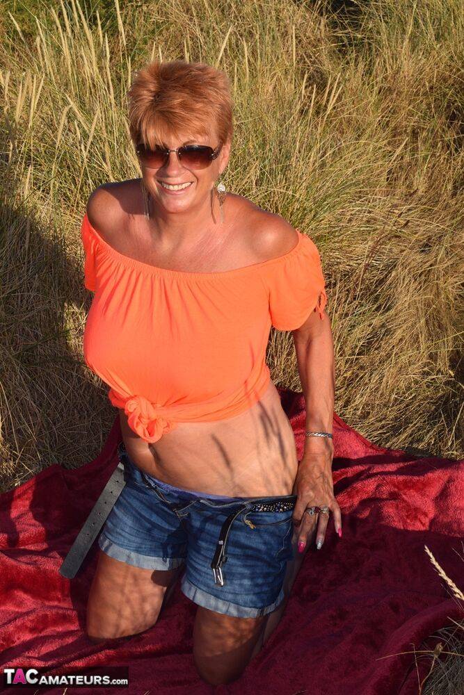 Fit older lady Dimonty exposes big naturals on a blanket overlooking the ocean - #6