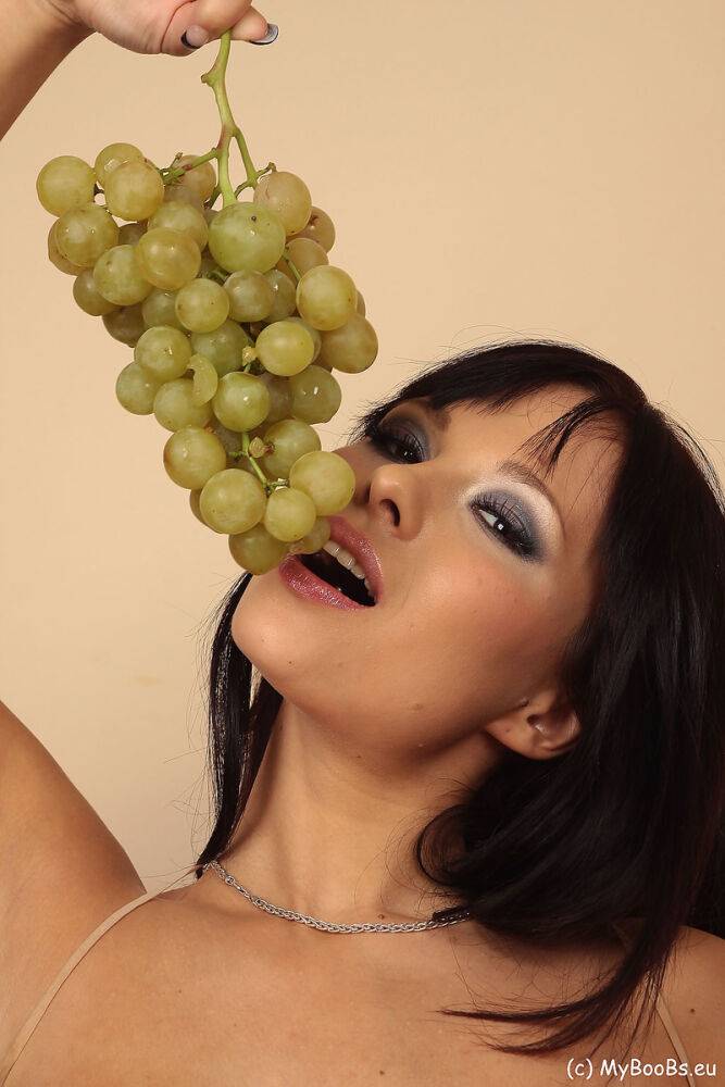 Hot brunette Domino munches on a grape bunch while removing her clothes - #15