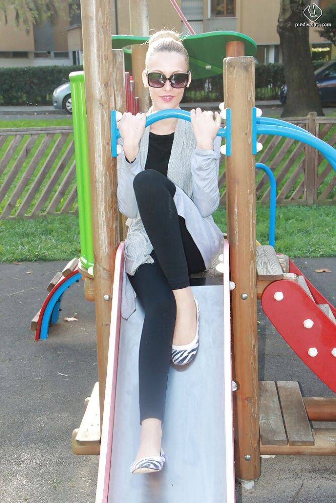 Lovely Christelle is showing her fine feet on a children playground - #13