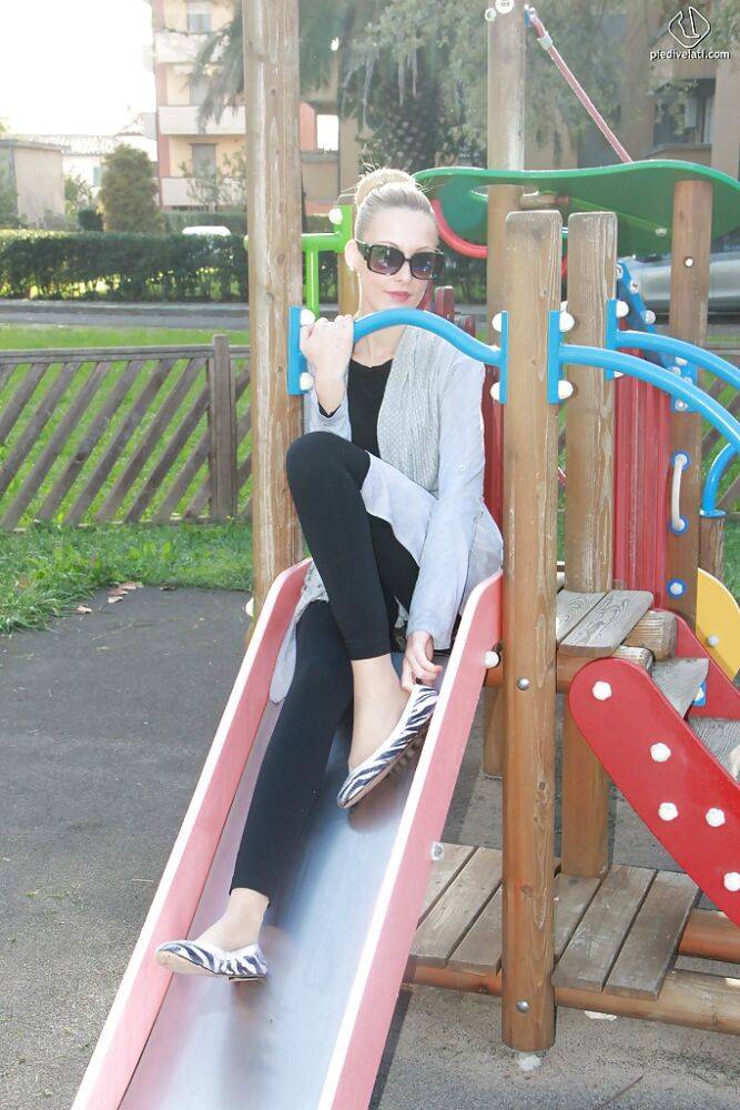 Lovely Christelle is showing her fine feet on a children playground - #4