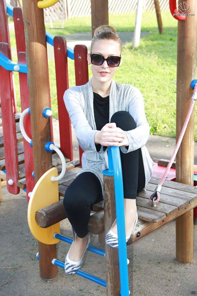 Lovely Christelle is showing her fine feet on a children playground - #11