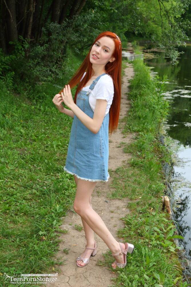 Young redhead Sherice exposes her slender body near a calm body of water - #16