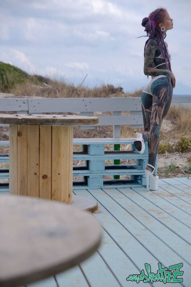 Heavily tattooed girl models a bikini in heels on a beach patio - #2