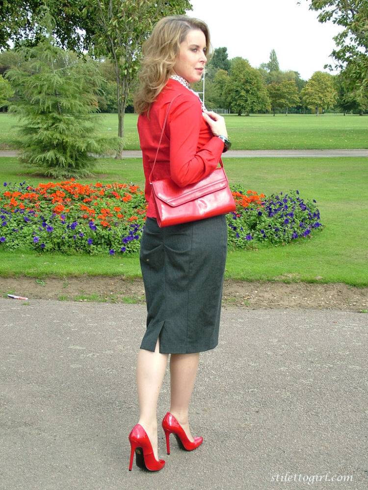 Mature woman crosses her hose covered legs in a long skirt and red pumps - #6