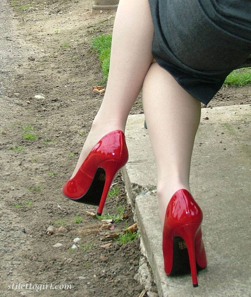 Mature woman crosses her hose covered legs in a long skirt and red pumps - #12