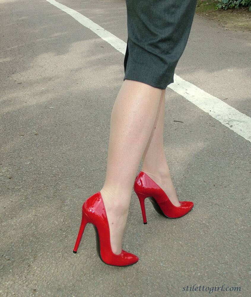 Mature woman crosses her hose covered legs in a long skirt and red pumps - #3