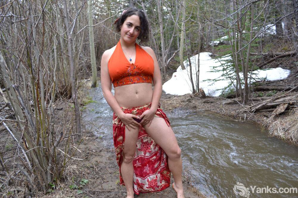 Busty amateur pets her beaver while bent over next to a brook in the woods - #12