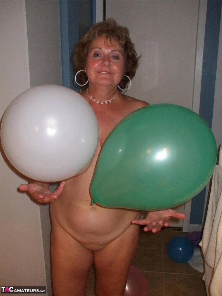 Mature lady models totally naked while playing with balloons - #16