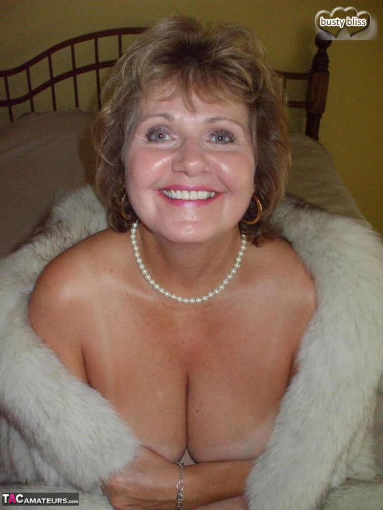 Older woman Busty Bliss licks her lips before showing her boobs in a fur coat - #12