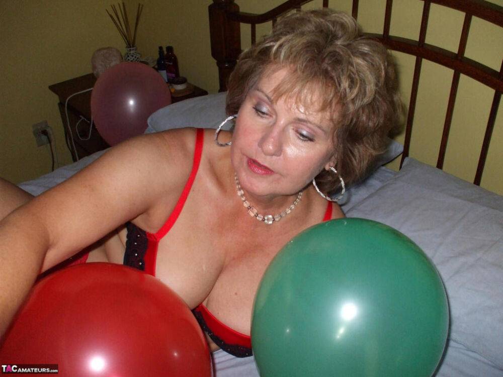 Older lady Busty Bliss plays with balloons before uncupping her natural tits - #14